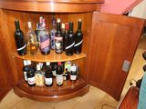 many bottles of alcohol on the corner of the cabinet
