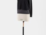un pull noir sur un mannequin, sur fond blanc