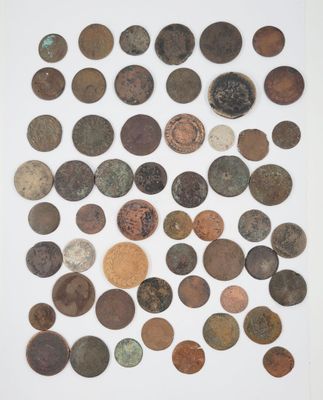 a pile of old coins sitting on top of a white surface