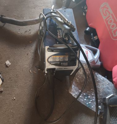 une petite machine posée par terre à côté d'un sac rouge