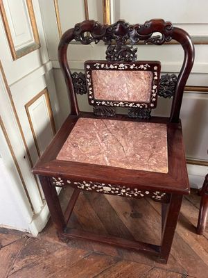 a wooden chair that has a pink seat on it