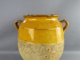 un vase jaune posé sur une table