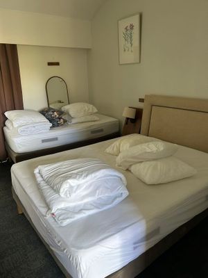 deux lits dans une chambre d'hôtel, recouverts de draps blancs