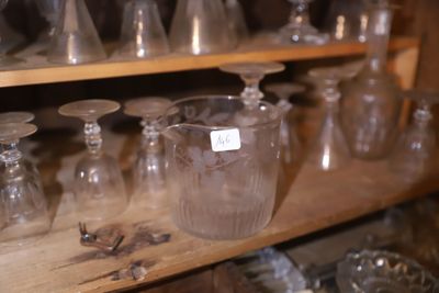 de nombreux vases en verre posés sur une étagère dans une pièce