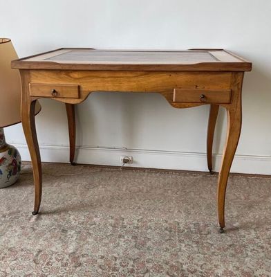 une petite table en bois avec un plateau en verre, posée à même le sol