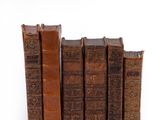plusieurs vieux livres sont empilés sur une surface blanche