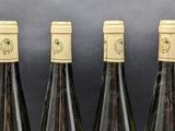 four bottles of wine are lined up on a table