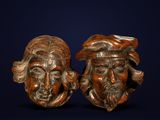 paire de têtes en bois sculptées représentant deux hommes portant un chapeau et une barbe