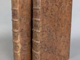two old books sitting on top of each other on a table