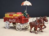 two horses pulling a coca cola cart with a man on it