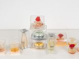 de nombreux parfums différents posés sur une table blanche