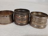 trois tasses plaquées argent, ornées de motifs, posées sur une surface blanche