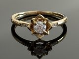 a close up of a diamond ring on a reflective surface