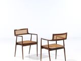 a pair of chairs with cane backrests on a white background