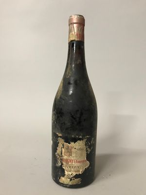 une vieille bouteille de vin posée sur une table blanche
