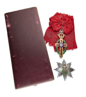 un livre rouge orné d'une croix, à côté d'une médaille