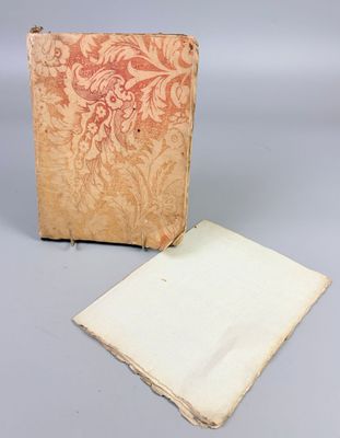 an old book sitting on top of a table next to a piece of paper