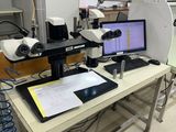 une table sur laquelle sont posés deux écrans et un ordinateur portable