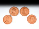 trois médaillons en bronze représentant des portraits, accrochés au mur