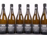 six bouteilles de vin sont alignées sur une table