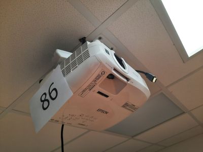 un vidéoprojecteur suspendu au plafond dans une pièce
