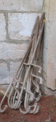 a pile of old tools leaning against a brick wall