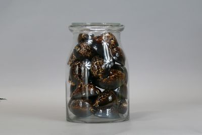 a glass jar filled with nuts on a white surface
