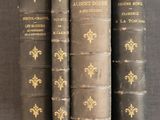 three old books are stacked on top of each other on a table