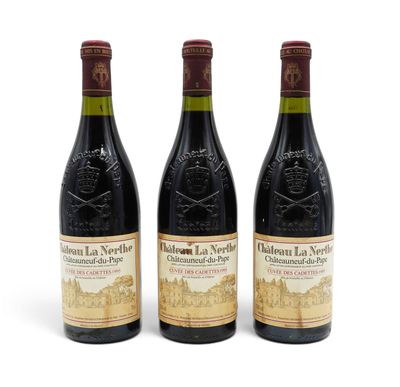 three bottles of red wine sitting next to each other on a white surface