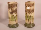 two vases with trees painted on them sitting on a table