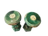 pair of green and gold pedestals with a medallion on the top