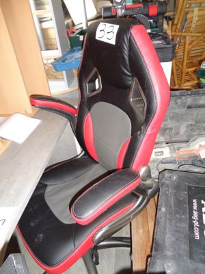 une chaise de bureau noire et rouge placée dans une pièce