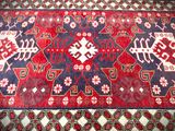 an image of a red and blue oriental rug on a wooden floor