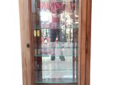 une vitrine avec une porte vitrée et des étagères