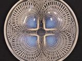 a glass plate with a design on it on a black surface