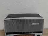 une radio posée sur un parquet, près d'un mur
