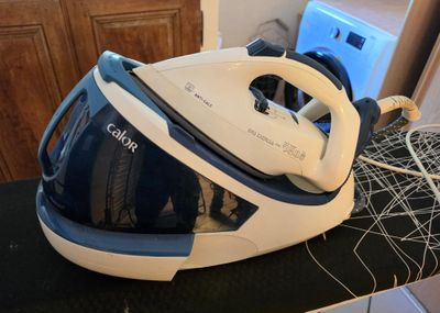 a blue and white steam iron sitting on a counter