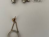deux paires de boucles d'oreilles et une bague posées sur une assiette blanche