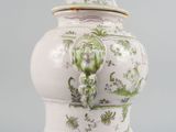 a white vase with a green and white design on it
