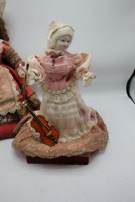 deux figurines représentant une femme et un homme avec un violon