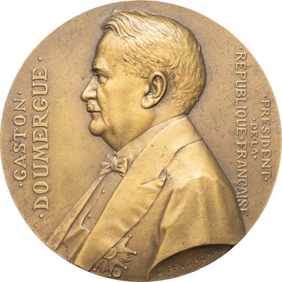 une image représentant une médaille de bronze sur laquelle figure un homme en costume et nœud papillon