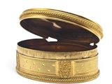 a gold box with a design on it on a white surface