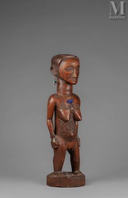 a wooden statue of a woman with a blue flower on her chest