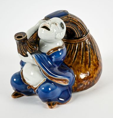 a ceramic figurine of a monkey holding a bag
