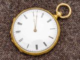 une montre de poche en or avec des chiffres romains