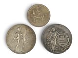 three silver coins, one of which is a woman and one of which is a man