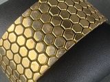 gold plated cuff bracelet with hexagons on it