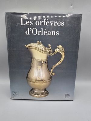 le livre est posé sur une table, à côté d'un pichet en argent