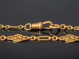 a close up of a gold chain with a clasp on a black surface