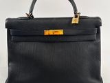 a black leather handbag with gold hardware on the handle